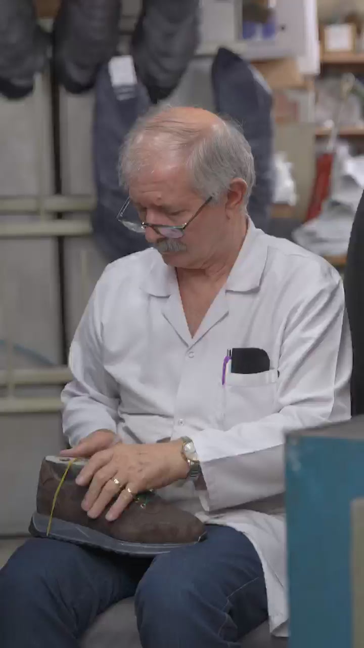 ShoeLab artisan crafting a leather shoe in the workshop